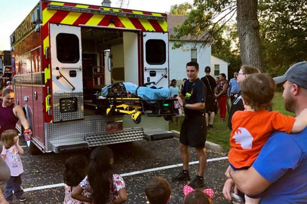 Firefighter speaking to residents and kids about the ambulance